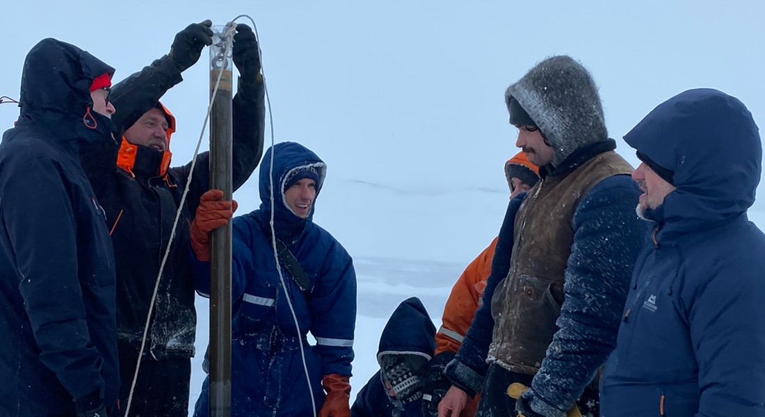 Team of scientists and postdocs examine the coring site on lake Valavatn